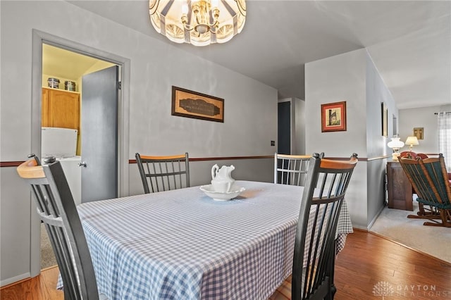 6719 Morrow Dr, Clayton, OH 45415 - dining area featuring a chandelier, wood finished floors, and baseboards
