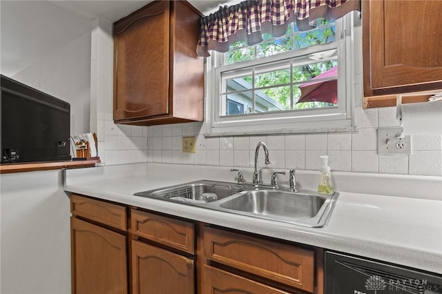 6719 Morrow Dr, Clayton, OH 45415 - kitchen with dishwashing machine, a sink, tasteful backsplash, light countertops, and brown cabinets