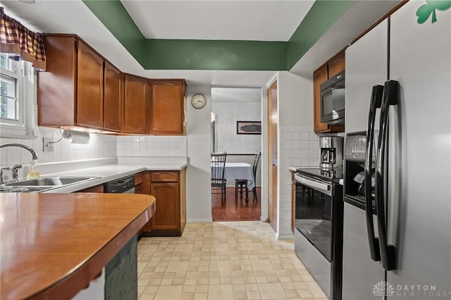 6719 Morrow Dr, Clayton, OH 45415 - kitchen featuring refrigerator with ice dispenser, a sink, stainless steel electric range, black microwave, and brown cabinetry