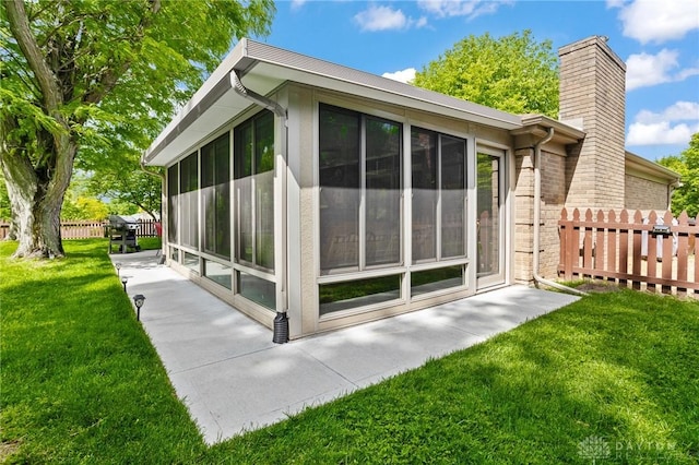 6719 Morrow Dr, Clayton, OH 45415 - view of side of property with a sunroom, a chimney, and brick siding