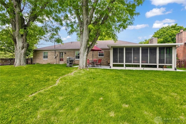 6719 Morrow Dr, Clayton, OH 45415 - rear view of property featuring a chimney, a sunroom, a patio area, and brick siding
