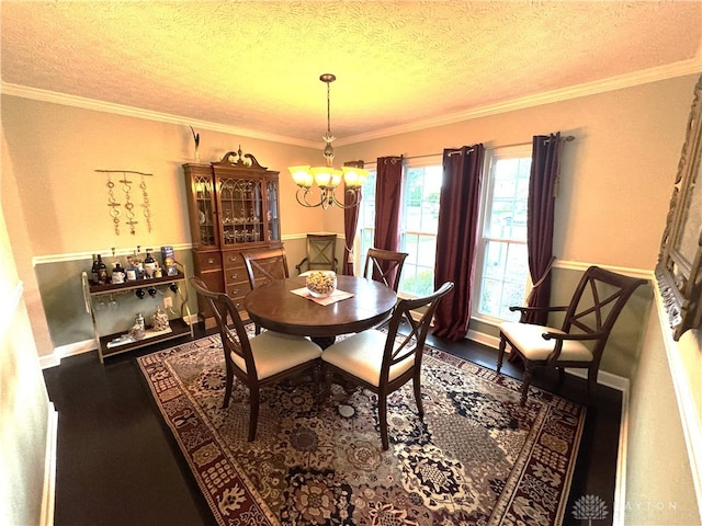1061 Dapple Ct, Fairborn, OH 45324 - dining space featuring a chandelier, baseboards, a textured ceiling, crown molding, and wood finished floors
