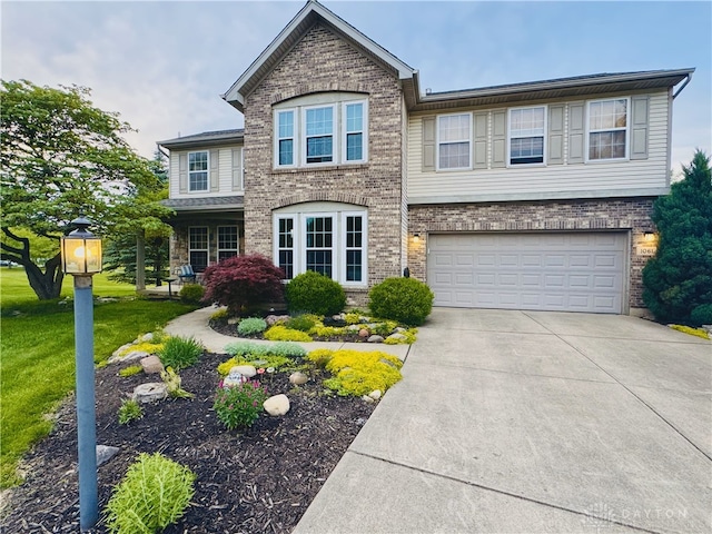 1061 Dapple Ct, Fairborn, OH 45324 - view of front of home with brick siding, a garage, driveway, and a front lawn