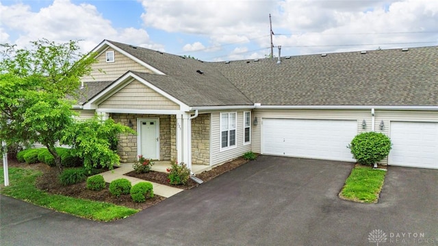 325 Bending Branch Ln, Miamisburg, OH 45342 - view of property featuring driveway, stone siding, a garage, and roof with shingles