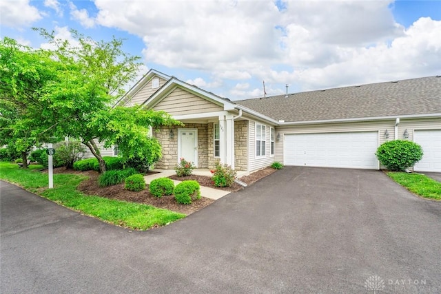 325 Bending Branch Ln, Miamisburg, OH 45342 - view of front of house featuring asphalt driveway, stone siding, an attached garage, and a shingled roof