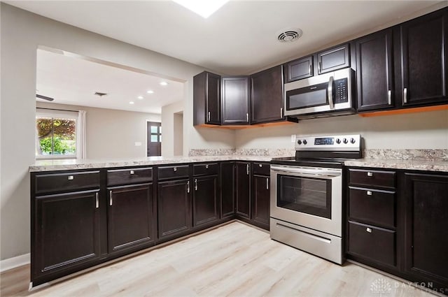 6123 Millbrook Dr, Washington Twp, OH 45459 - kitchen featuring stainless steel appliances, light wood-style flooring, a peninsula, recessed lighting, and light stone countertops