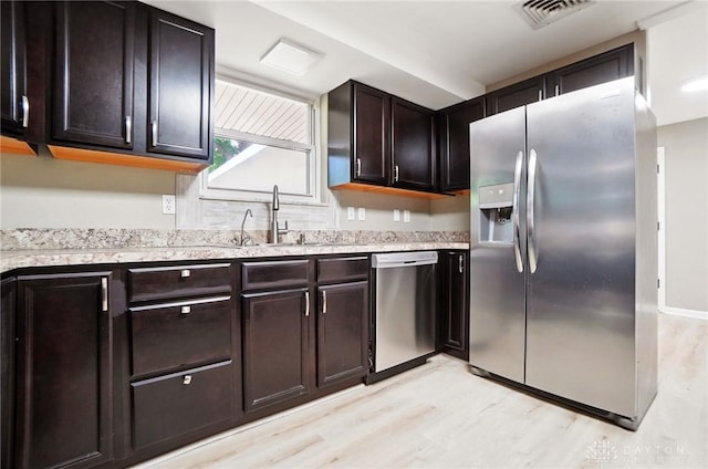 6123 Millbrook Dr, Washington Twp, OH 45459 - kitchen with stainless steel appliances, light wood-style floors, a sink, light countertops, and dark brown cabinetry