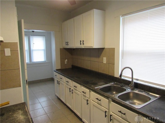 2455 Catalpa Dr, Dayton, OH 45406 - kitchen featuring a sink, light tile patterned floors, white cabinets, and tasteful backsplash