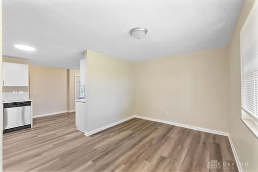 1108 Donson Dr, Kettering, OH 45429 - unfurnished living room with wood finished floors and baseboards