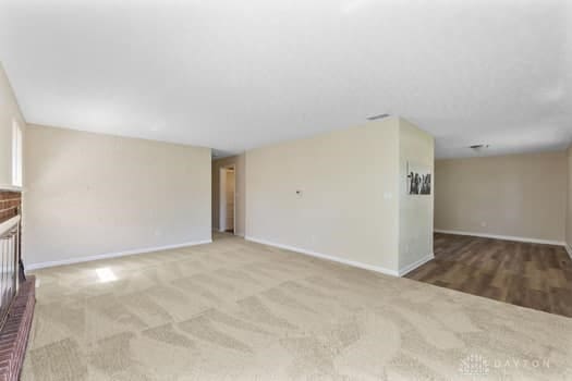 1108 Donson Dr, Kettering, OH 45429 - unfurnished living room featuring baseboards and carpet