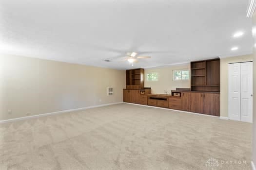 1108 Donson Dr, Kettering, OH 45429 - unfurnished living room featuring a ceiling fan, light colored carpet, and baseboards