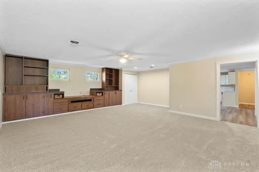 1108 Donson Dr, Kettering, OH 45429 - unfurnished living room featuring a ceiling fan, light carpet, and baseboards