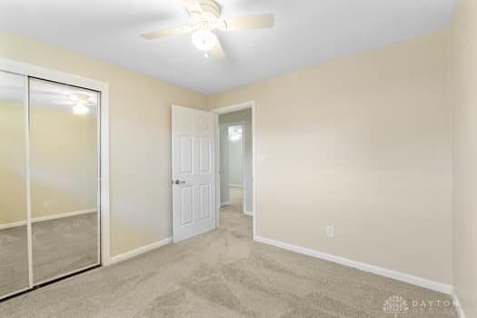 1108 Donson Dr, Kettering, OH 45429 - unfurnished bedroom with carpet flooring, baseboards, a closet, and ceiling fan
