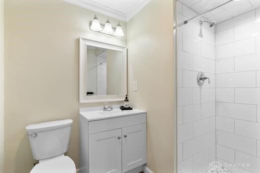1108 Donson Dr, Kettering, OH 45429 - bathroom featuring vanity, toilet, tiled shower, and ornamental molding