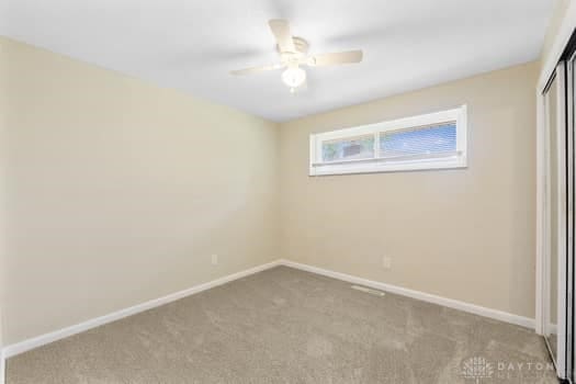 1108 Donson Dr, Kettering, OH 45429 - unfurnished bedroom featuring a closet, carpet, baseboards, and ceiling fan