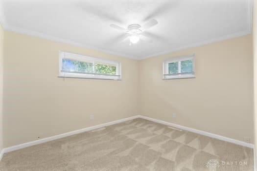 1108 Donson Dr, Kettering, OH 45429 - unfurnished room with light carpet, plenty of natural light, baseboards, and ceiling fan