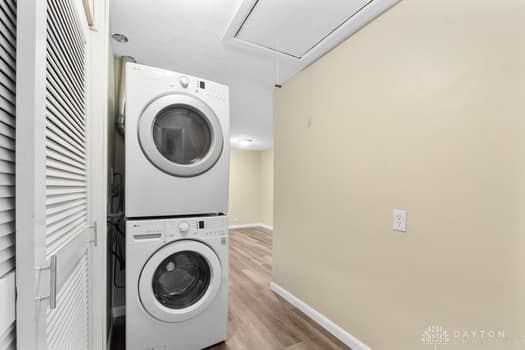 1108 Donson Dr, Kettering, OH 45429 - laundry area with stacked washer / dryer, attic access, wood finished floors, and baseboards