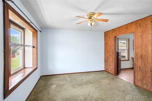 1385 Kylemore Dr, Xenia, OH 45385 - carpeted empty room featuring wood walls, a ceiling fan, and baseboards