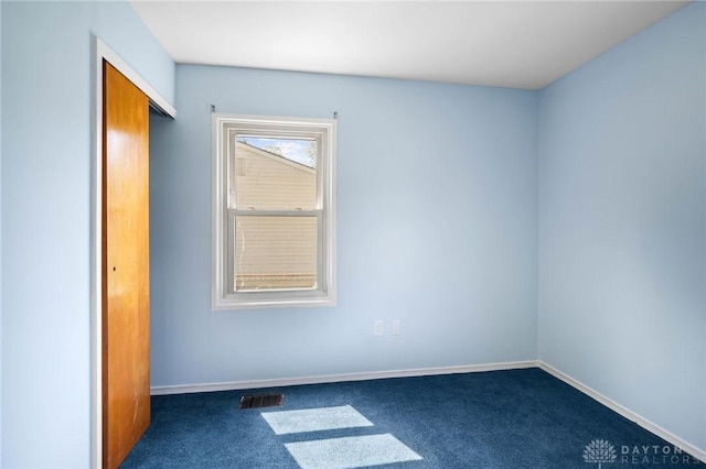 1385 Kylemore Dr, Xenia, OH 45385 - unfurnished bedroom featuring dark colored carpet, baseboards, and a closet