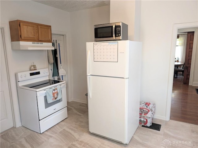 519 Prytania Ave, Hamilton, OH 45013 - kitchen with white appliances, under cabinet range hood, brown cabinets, and baseboards