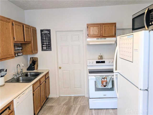 519 Prytania Ave, Hamilton, OH 45013 - kitchen featuring white appliances, under cabinet range hood, a sink, brown cabinetry, and light countertops