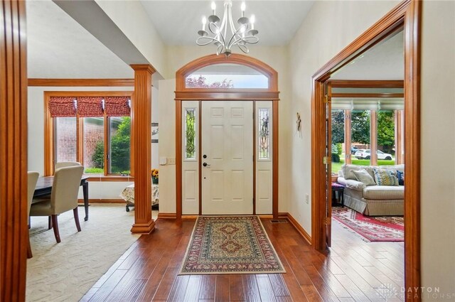 1403 Timshel St, Sugarcreek Township, OH 45440 - entryway with a chandelier, decorative columns, dark wood-type flooring, and baseboards