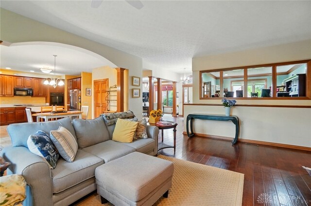1403 Timshel St, Sugarcreek Township, OH 45440 - living room with a chandelier, arched walkways, hardwood / wood-style floors, and baseboards