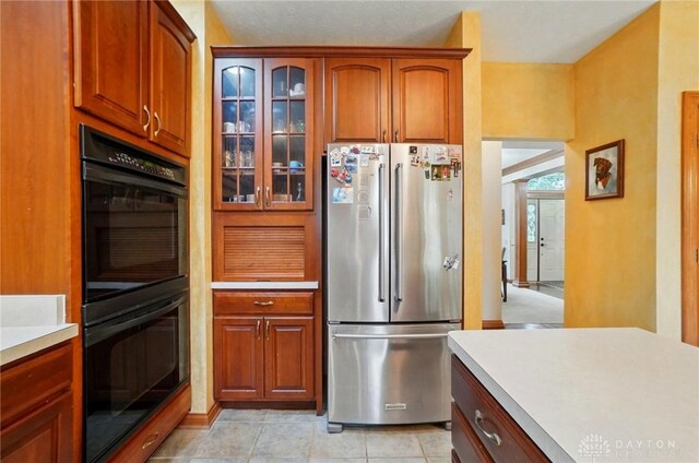 1403 Timshel St, Sugarcreek Township, OH 45440 - kitchen with freestanding refrigerator, light countertops, glass insert cabinets, and brown cabinets
