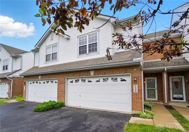 9235 Great Lakes Cir, Washington Twp, OH 45458 - view of front of house featuring brick siding, driveway, an attached garage, and a shingled roof