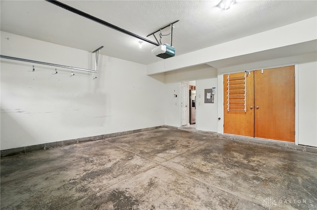 9235 Great Lakes Cir, Washington Twp, OH 45458 - garage with a garage door opener, stainless steel fridge with ice dispenser, and baseboards