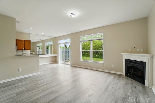 9235 Great Lakes Cir, Washington Twp, OH 45458 - unfurnished living room featuring light wood-style flooring, a fireplace, baseboards, and recessed lighting