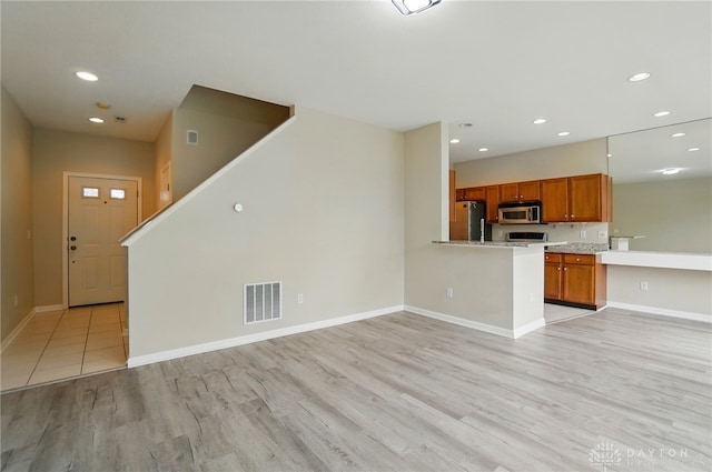 9235 Great Lakes Cir, Washington Twp, OH 45458 - unfurnished living room featuring light wood-style flooring, recessed lighting, baseboards, and stairway