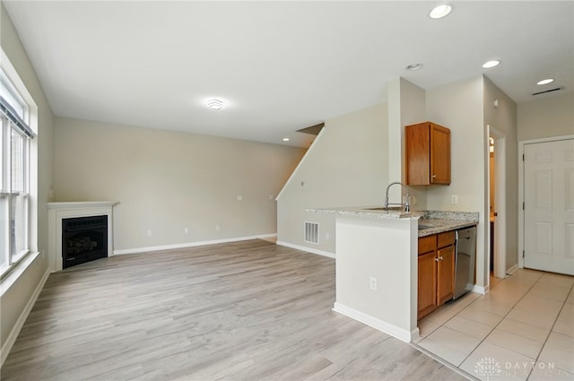 9235 Great Lakes Cir, Washington Twp, OH 45458 - kitchen with brown cabinets, stainless steel dishwasher, light wood-style flooring, baseboards, and recessed lighting