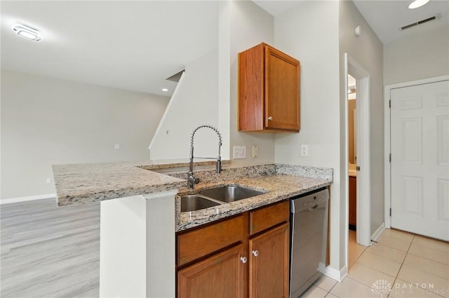9235 Great Lakes Cir, Washington Twp, OH 45458 - kitchen with stainless steel dishwasher, brown cabinetry, light stone counters, baseboards, and a sink