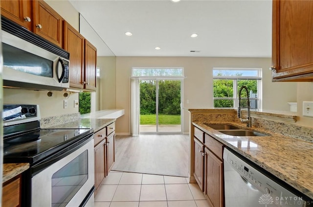 9235 Great Lakes Cir, Washington Twp, OH 45458 - kitchen featuring appliances with stainless steel finishes, a sink, brown cabinetry, plenty of natural light, and recessed lighting
