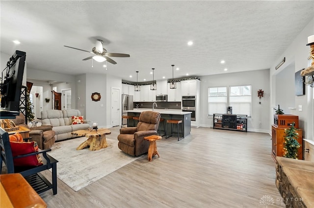9777 Winding Creek Blvd, Clearcreek Twp, OH 45458 - living room featuring a ceiling fan, light wood finished floors, baseboards, recessed lighting, and a textured ceiling
