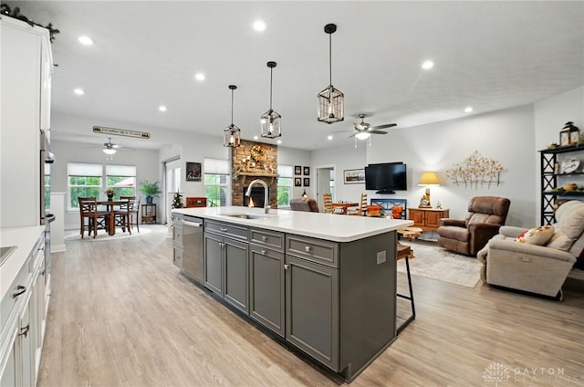 9777 Winding Creek Blvd, Clearcreek Twp, OH 45458 - kitchen featuring ceiling fan, a sink, gray cabinets, stainless steel dishwasher, and a fireplace
