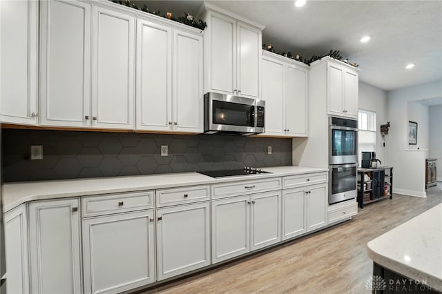 9777 Winding Creek Blvd, Clearcreek Twp, OH 45458 - kitchen with appliances with stainless steel finishes, light wood-type flooring, recessed lighting, backsplash, and light countertops