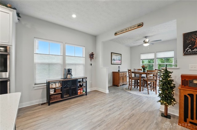 9777 Winding Creek Blvd, Clearcreek Twp, OH 45458 - dining area featuring healthy amount of natural light, light wood finished floors, ceiling fan, a textured ceiling, and baseboards