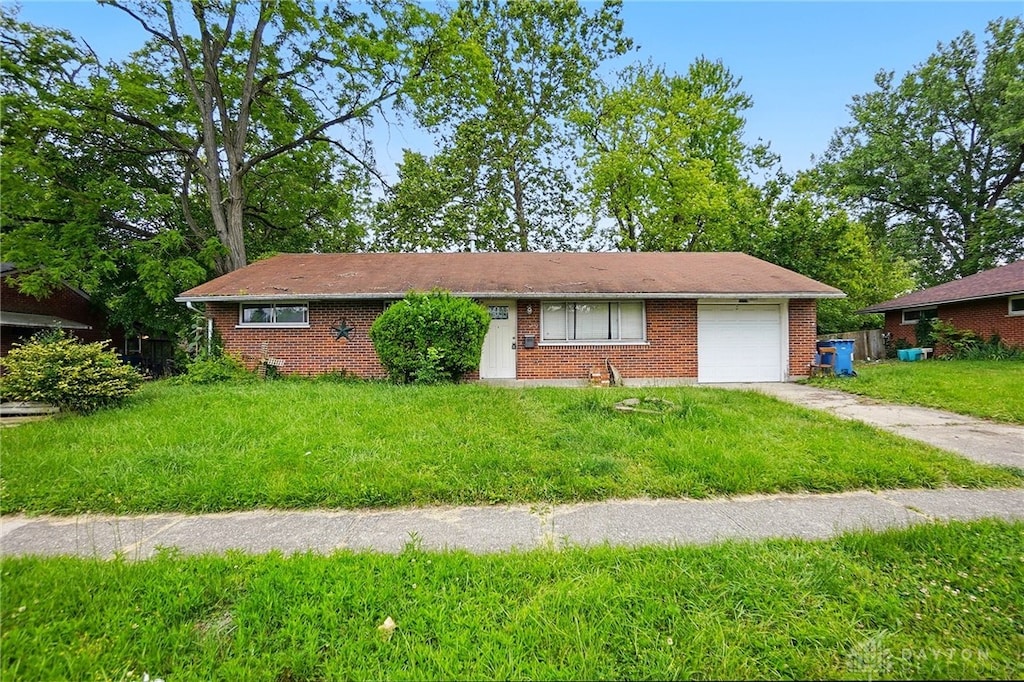 5059 Key W Dr, Dayton, OH 45424 - ranch-style house with an attached garage, driveway, brick siding, and a front lawn