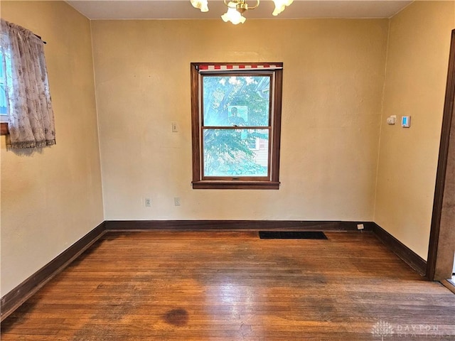 1800 Patterson Rd, Dayton, OH 45420 - unfurnished room featuring hardwood / wood-style floors, a chandelier, and baseboards