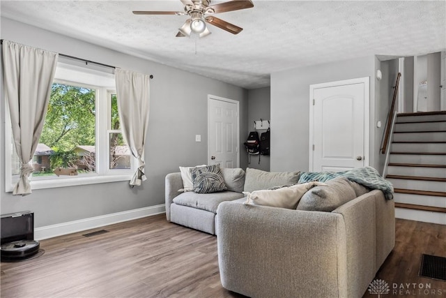 2089 Clearview Dr, Bellbrook, OH 45305 - living area featuring a textured ceiling, ceiling fan, stairway, baseboards, and wood finished floors