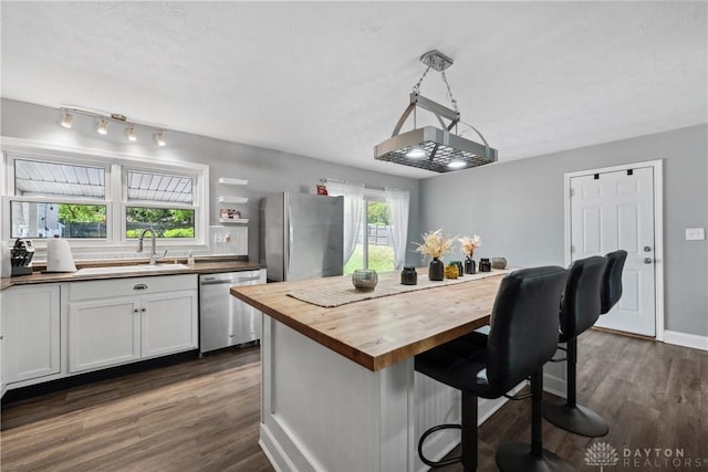 2089 Clearview Dr, Bellbrook, OH 45305 - kitchen with stainless steel appliances, butcher block counters, a sink, dark wood-style flooring, and a kitchen breakfast bar