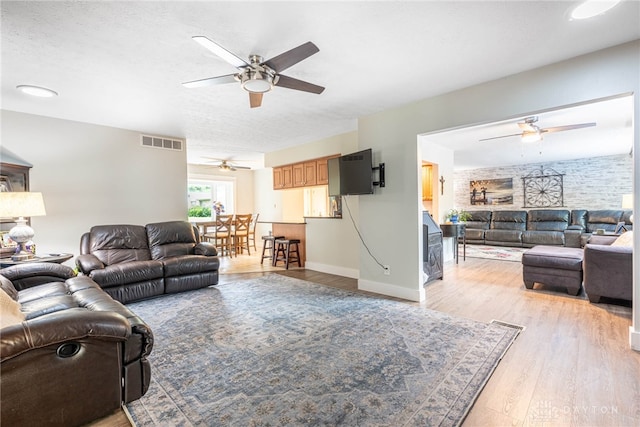 4491 Powder Horn Dr, Beavercreek, OH 45432 - living room with a ceiling fan, light wood-type flooring, baseboards, and a textured ceiling