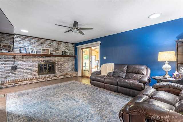 4491 Powder Horn Dr, Beavercreek, OH 45432 - living area with ceiling fan, brick wall, wood finished floors, and a fireplace