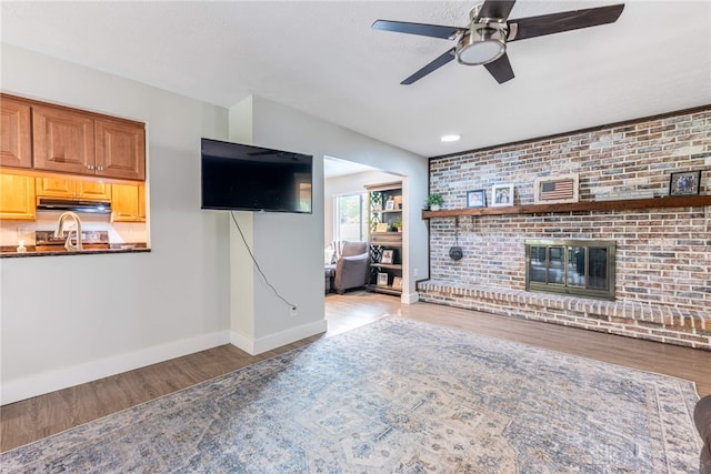 4491 Powder Horn Dr, Beavercreek, OH 45432 - living area featuring ceiling fan, wood finished floors, baseboards, and a fireplace
