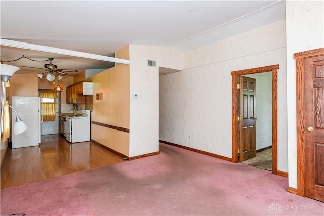 903 Kennison Ave, New Carlisle, OH 45344 - unfurnished living room featuring carpet, a ceiling fan, vaulted ceiling, and baseboards