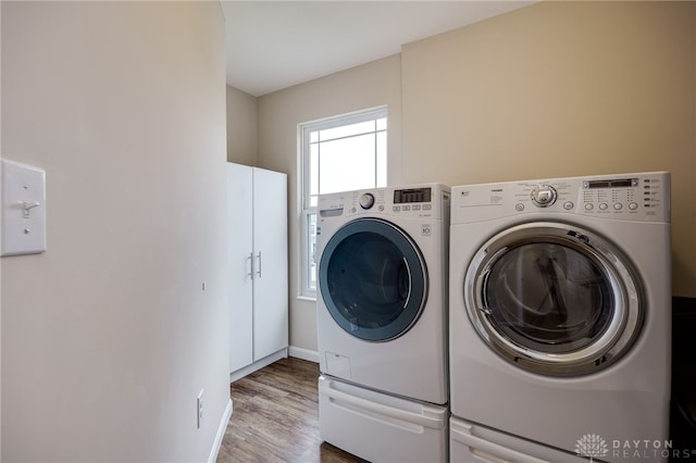 148 Oasis Ct, Springboro, OH 45066 - laundry room with separate washer and dryer, cabinet space, wood finished floors, and baseboards