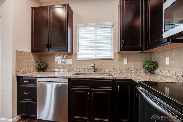148 Oasis Ct, Springboro, OH 45066 - kitchen with appliances with stainless steel finishes, a sink, tasteful backsplash, and light stone countertops