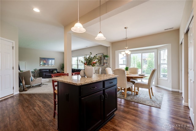 148 Oasis Ct, Springboro, OH 45066 - kitchen featuring a breakfast bar area, dark wood-type flooring, decorative light fixtures, a kitchen island, and recessed lighting
